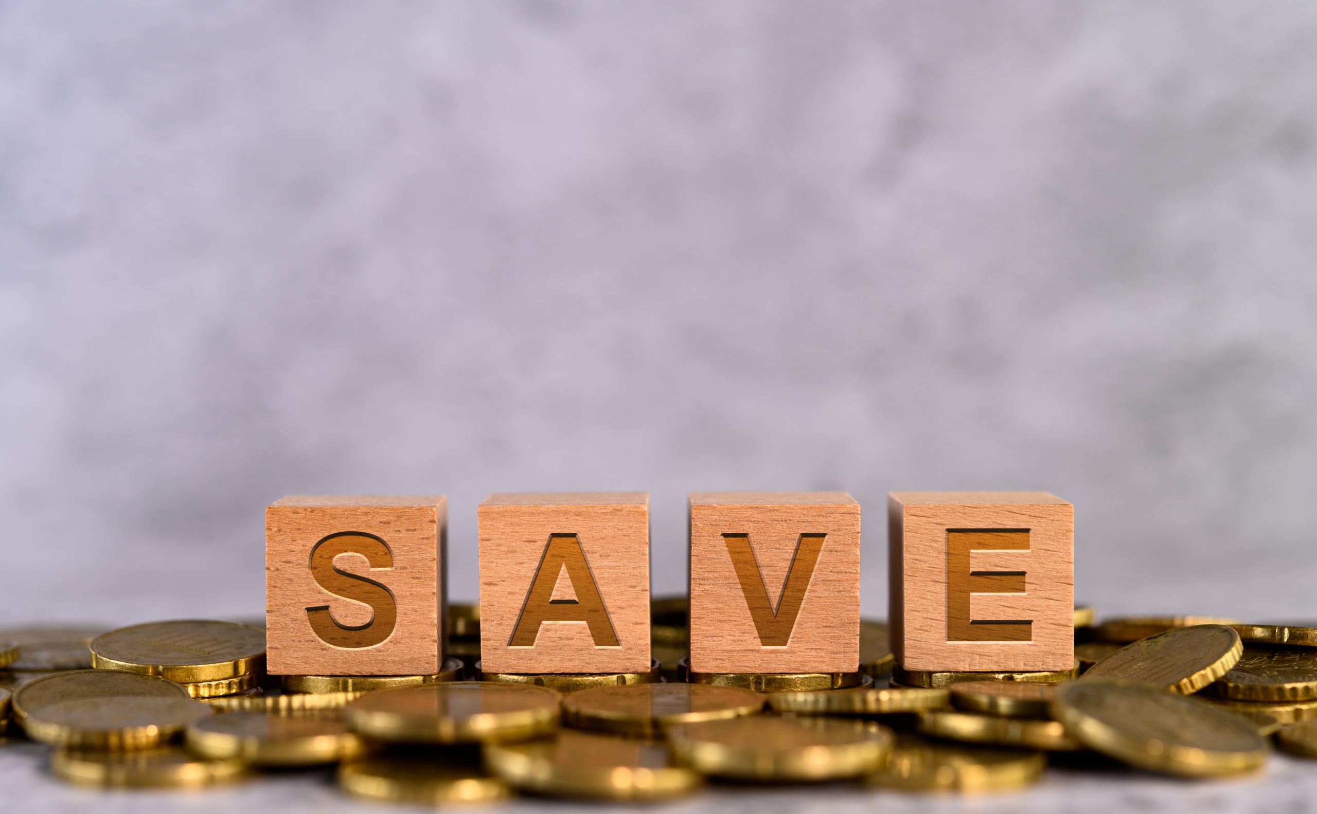 Save word alphabet wooden cube letters placed on a gold coin